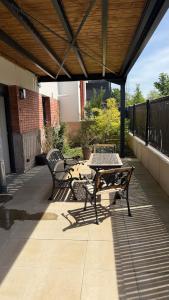 a patio with two benches and a table on a patio at Max Wittelsheim in Wittelsheim