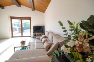 a living room with a couch and a tv at Casa ATARAXIA in Boiro