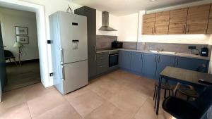 a kitchen with blue cabinets and a white refrigerator at Max Wittelsheim in Wittelsheim