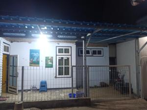 a house with a fence in front of it at Wahid Homestay in Ketapang