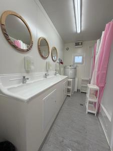 a bathroom with a sink and two mirrors on the wall at Highway to Hel in Jastarnia +40 photos