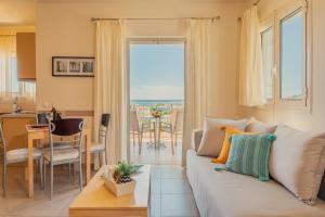 a living room with a couch and a table with a view at Vereniki Apartments in Finikounta