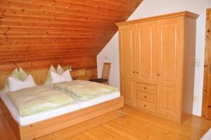 a bedroom with a bed and a wooden wall at Ferienhof Berger in Rossleithen