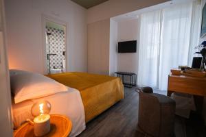 a hotel room with a bed and a table with a candle at Garibaldi Suite B&B in Salerno