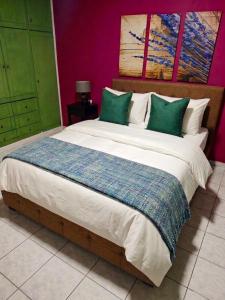 a bedroom with a large bed with green and white pillows at ELVAJO Apartment in Zacharo