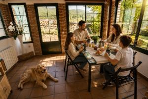 a group of people sitting around a table with a dog at Casa rural Paraje de Yuste in Cuacos de Yuste +30 photos