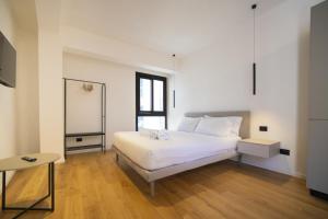 a bedroom with a white bed and a mirror at Solemar Sicilia - Torre Maqueda in Palermo