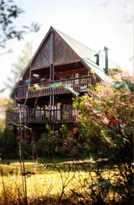a large wooden house with a porch and a balcony at Little Lions in Dullstroom