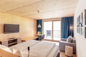a hotel room with a bed and a tv at Boutique Hotel LechZeit in Elmen