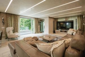 a living room with a large couch and a tv at Maison Villa Scherlin in Bardolino
