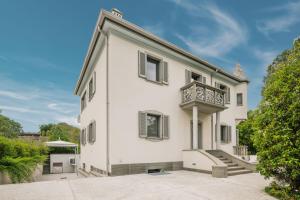 a white building with a balcony on top of it at Maison Villa Scherlin in Bardolino