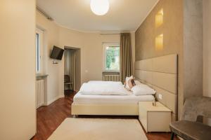 a bedroom with a bed and a tv and a couch at Maison Villa Scherlin in Bardolino +45 photos