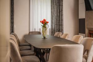 a vase of flowers sitting on a table with chairs at Maison Villa Scherlin in Bardolino
