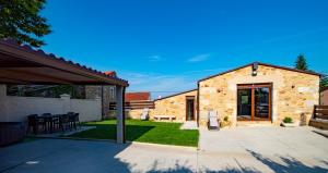 a backyard with a stone house with a patio at Casa ATARAXIA in Boiro