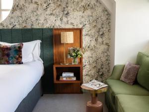 a bedroom with a bed and a couch and a table at Dylan in Dublin