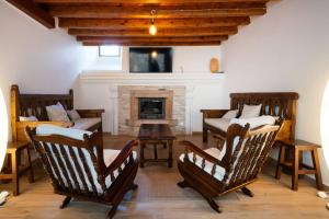 a living room with rocking chairs and a fireplace at Hotel Rural Alecook in Valcabado