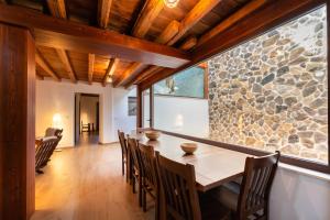 a dining room with a table and chairs and a stone wall at Hotel Rural Alecook in Valcabado