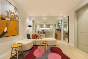 a living room with a white couch and two tables at The District Lekki by GCI in Lekki Phase 1