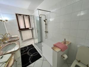 ein weißes Badezimmer mit Dusche und Waschbecken in der Unterkunft Giulia Cottage in Strona + 16 Fotos
