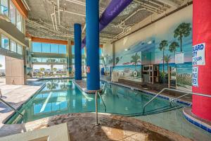 a swimming pool in a building with a mural on the wall at Dunes Village in Myrtle Beach