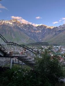 a stairway leading up to a mountain with a city at Maia's Guest House Gergeti in Kazbegi