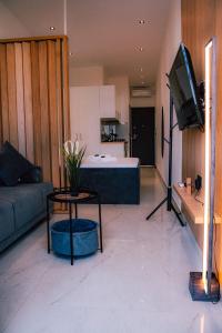 a living room with a couch and a table and a tv at fenias luxury studios in Kallithea Halkidikis