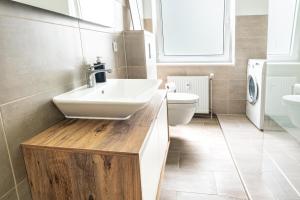 a bathroom with a white sink and a toilet at Modern Stay in Lemgo +14 photos