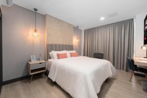 a bedroom with a large white bed and a desk at Riomaggiore City Tower in Cali