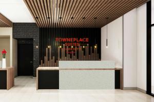 a lobby with a counter with a sign on the wall at TownePlace Suites by Marriott Vaughan in Vaughan