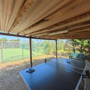 a ping pong table in a pavilion with a tennis court at Agriturismo Le Pescine in Vada