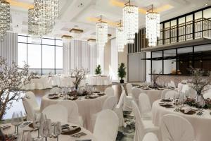 a banquet hall with white tables and chairs and chandeliers at TownePlace Suites by Marriott Vaughan in Vaughan