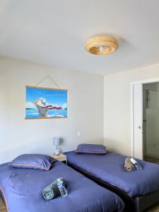 a room with two beds and a picture on the wall at Les Pignottes in Gujan-Mestras