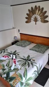 a bedroom with a bed with a tropical print at Studio du PARADIS et Maison Vue sur Mer à 10 minutes des belles plages in Le Marin