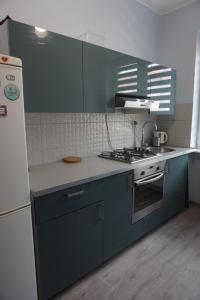 a kitchen with blue cabinets and a white refrigerator at Baltic Rooms Gdańsk in Skorka