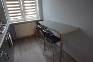a small kitchen with a table and two chairs at Baltic Rooms Gdańsk in Skorka