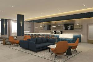 a lobby with couches and chairs and a bar at Courtyard by Marriott Torreón in Torreón