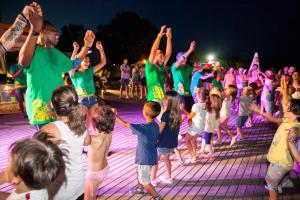 a group of children dancing on a dance floor at night at Camping Pineta - Nikoli Tour in Cesenatico +26 photos