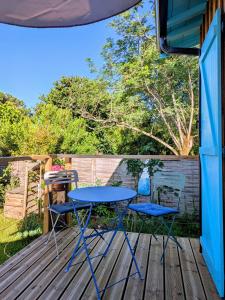 a blue table and two chairs on a deck at Les Pignottes in Gujan-Mestras +4 photos
