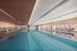 a large swimming pool with chairs and a swimming pool at Beijing Marriott Hotel Yanqing in Yanqing