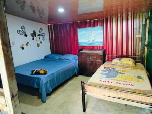 a bedroom with two beds and a dresser in it at Bosque celeste in Rio Celeste