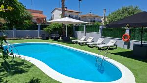 a swimming pool in a yard with chairs and an umbrella at Try and Try in Cunit