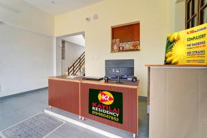 a reception desk with a sign on it in a room at Kayilai Residency in Pīlamedu