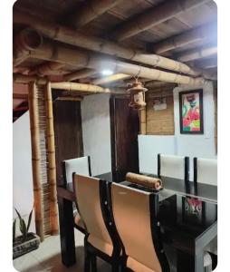 a dining room with a black table and chairs at Guaduales Apartamento in Salento