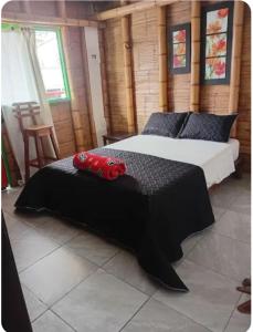 a bedroom with two beds with black sheets and red pillows at Guaduales Apartamento in Salento