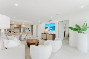 a living room with white furniture and a kitchen at The Mizner - 2BR Waterfront Boca Suite in Boca Raton +66 photos