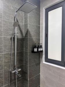 a shower with a glass door in a bathroom at NÚP Homestay Huế in Thôn Dương Xuân Hạ