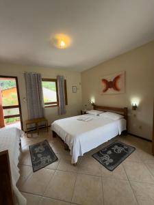 a bedroom with two beds and two windows at Pousada Tempo Rei in Boicucanga +94 photos