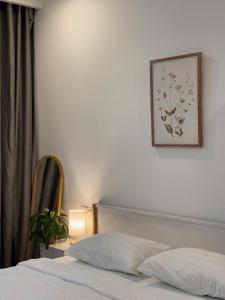 a bedroom with a bed and a picture on the wall at NÚP Homestay Huế in Thôn Dương Xuân Hạ