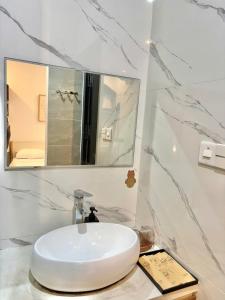 a bathroom with a white sink and a mirror at NÚP Homestay Huế in Thôn Dương Xuân Hạ +12 photos