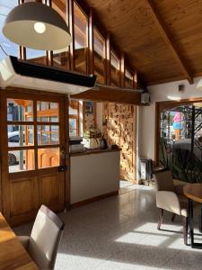 eine Küche mit Holzdecke, Tisch und Stühlen in der Unterkunft Don Costa in Chos Malal